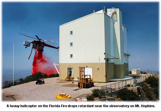 A helicopter drops retardant near the observatory